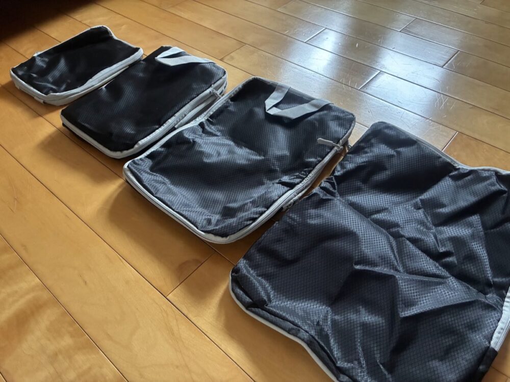 衣類を圧縮できる圧縮袋4つを床に並べたところ