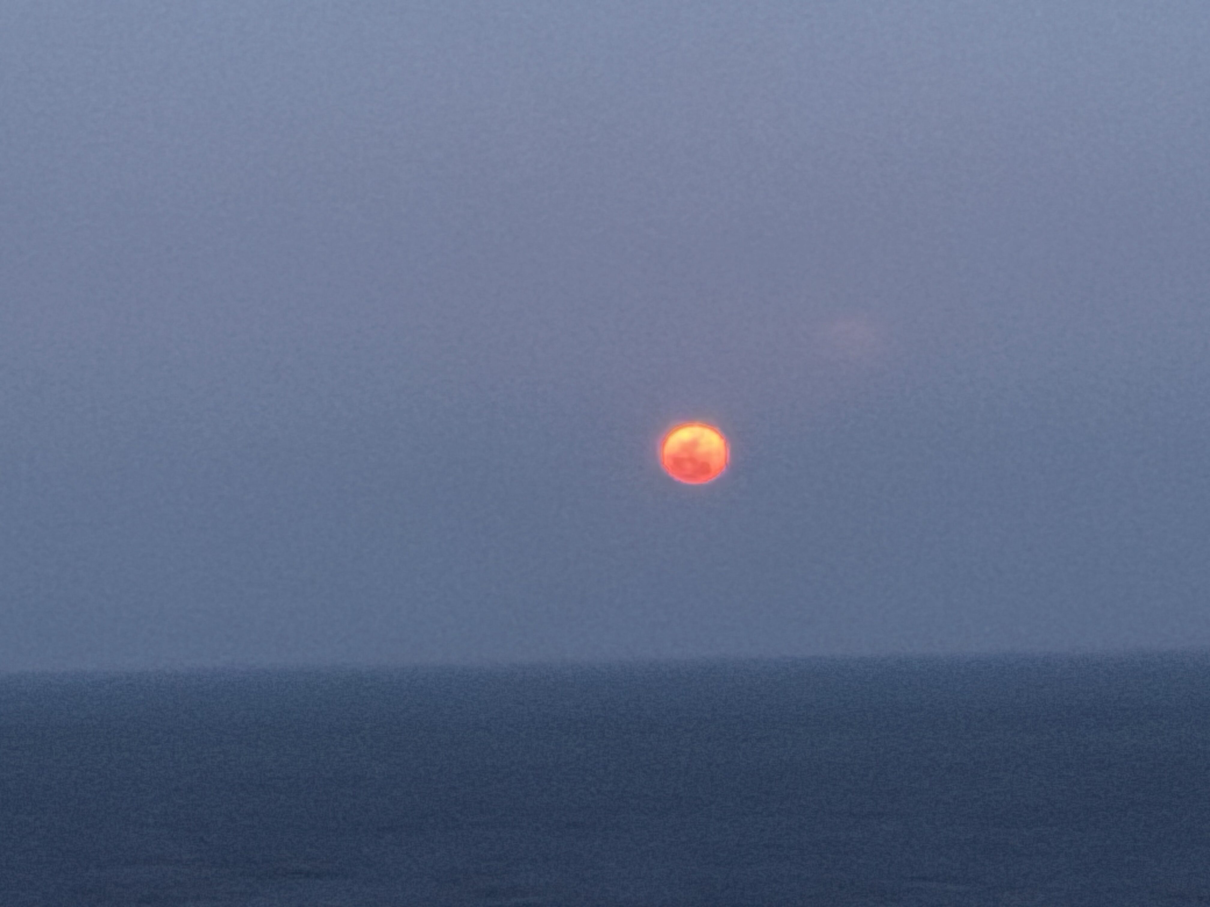 海に昇る満月